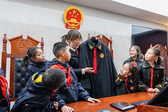 圖②：干警向同學(xué)們介紹法袍。