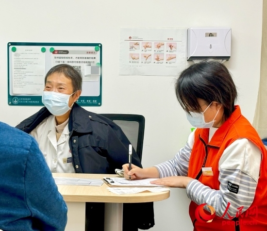 秦苑（中）接診患者。人民網(wǎng)記者 金慧慧攝