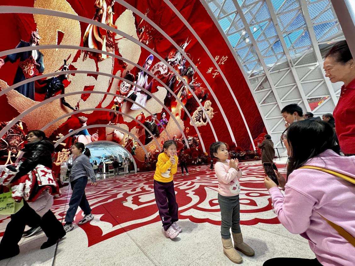 乙巳蛇年春節(jié)期間，影迷在《哪吒之魔童鬧?！肪薹?bào)前拍照打卡。