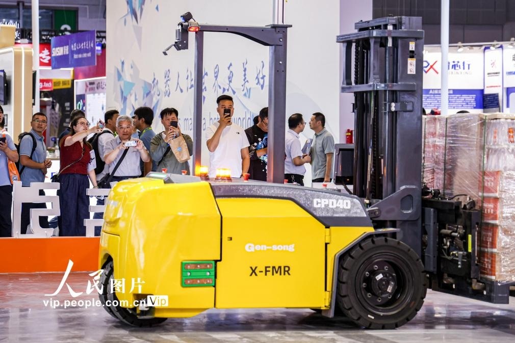 第24屆中國工博會(huì)現(xiàn)場，觀眾觀看叉取機(jī)器人作業(yè)演示。王初攝（人民圖片網(wǎng)）