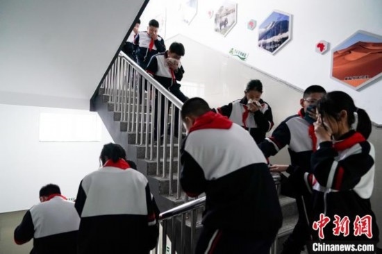  圖為學(xué)生們進(jìn)行應(yīng)急疏散演練。中新社記者 趙宇航 攝