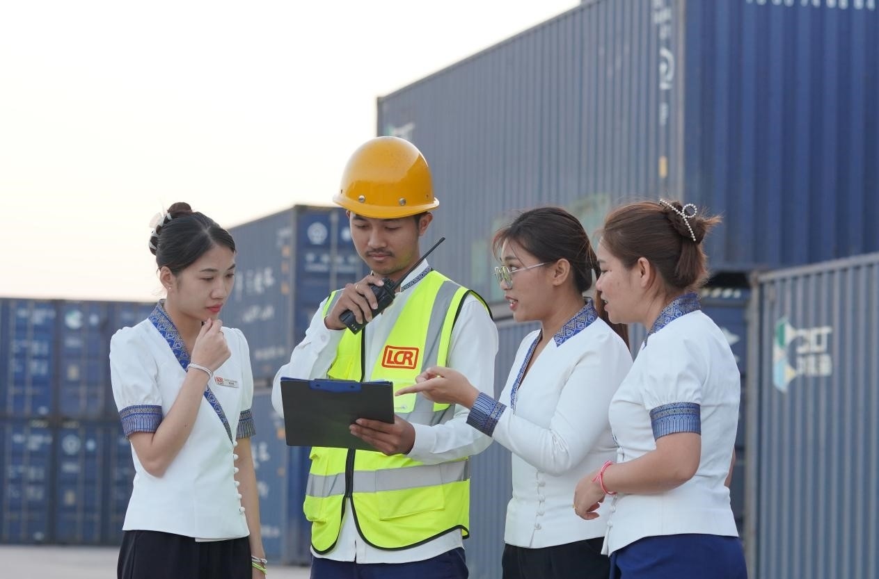 萬(wàn)象南站貨運(yùn)值班員陳尼啦（左一）與同事在一起討論工作。老中鐵路有限公司供圖