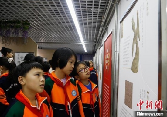 圖為學生參觀青海省博物館“1+3”主題流動展覽，了解木舞俑。中新社記者 馬銘言 攝