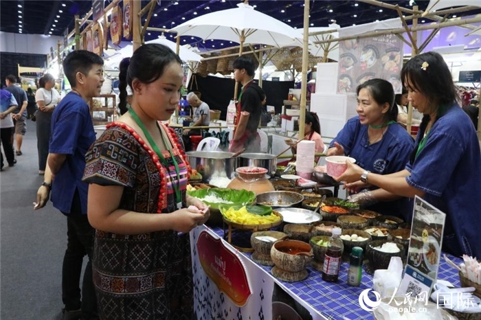 游客在攤位前購買特色美食。朱瀟逸攝