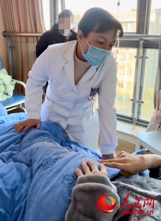 鄧茜查房時(shí)詢問患者情況。人民網(wǎng)記者 金慧慧攝