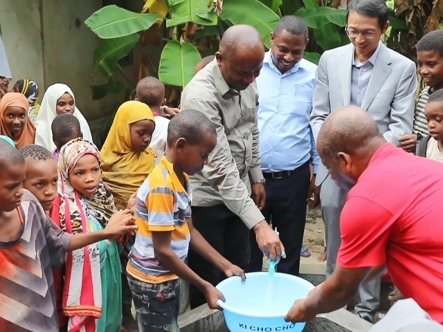 在日前舉行的安全供水工程揭牌儀式上，當(dāng)?shù)匦∨笥言诠┧c(diǎn)接水。 施亮攝