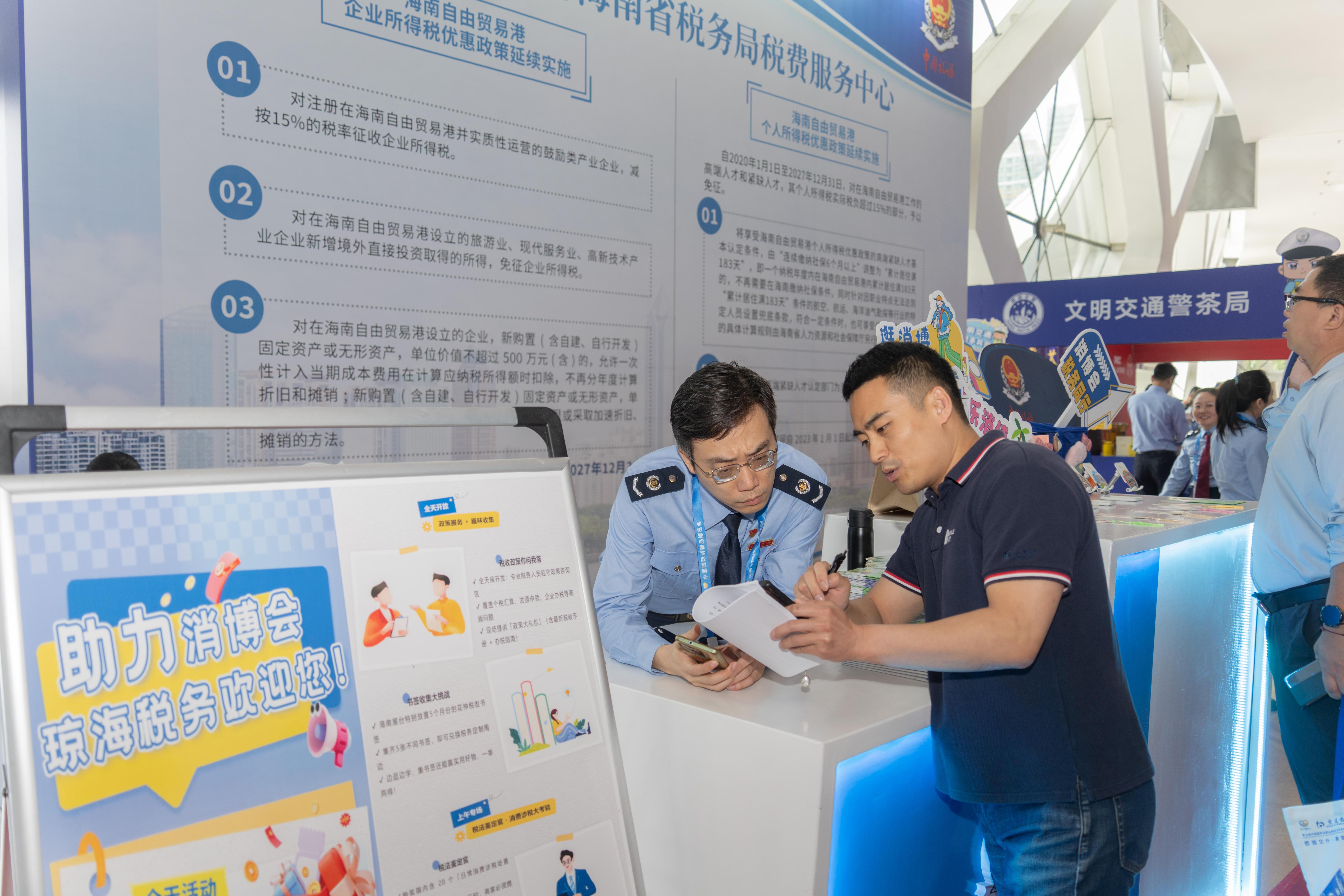 稅務(wù)服務(wù)臺工作人員向記者介紹服務(wù)參展外商的具體舉措。人民網(wǎng)記者 許崢攝