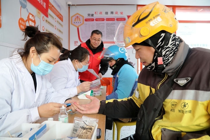 2025年3月5日，志愿者在山東省棗莊市市中區(qū)一工會驛站為外賣員免費測量血糖。新華社發(fā)（王海楠攝）