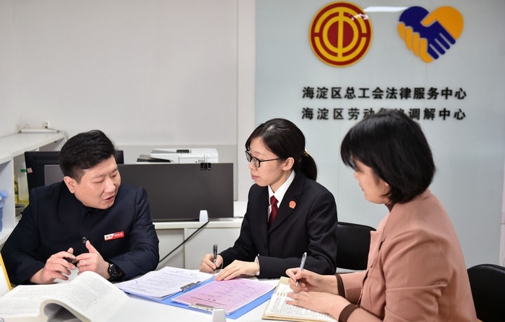 2025年3月6日，在北京市海淀區(qū)總工會勞動爭議調(diào)解中心，海淀區(qū)人民法院法官王琰（中）與該中心工作人員就糾紛化解情況進行溝通。新華社記者 趙婷婷 攝