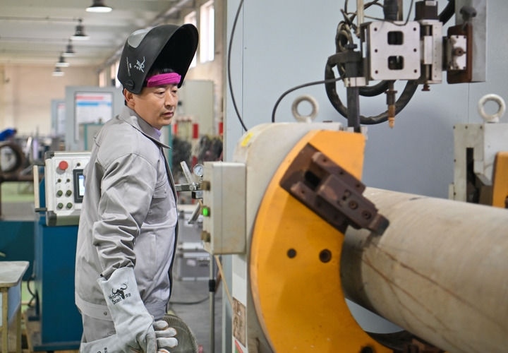 在中石化第四建設有限公司工匠學院，全國人大代表、中石化第四建設有限公司工匠學院焊接教練張振連操作自動焊機（2025年2月21日攝）。新華社記者 孫凡越 攝