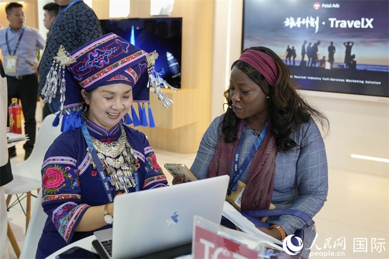 來自廣西的旅游業(yè)者同客戶交流。人民網(wǎng)塔里克·易卜拉欣攝