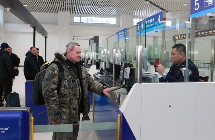 2024年12月10日，在黑河公路口岸旅檢大廳，黑河出入境邊防檢查站民警為首班次客車入境旅客辦理邊檢通關(guān)手續(xù)。當日，中國黑河公路口岸—俄羅斯卡尼庫爾干公路口岸旅客運輸正式開通。新華社發(fā)（劉松攝）