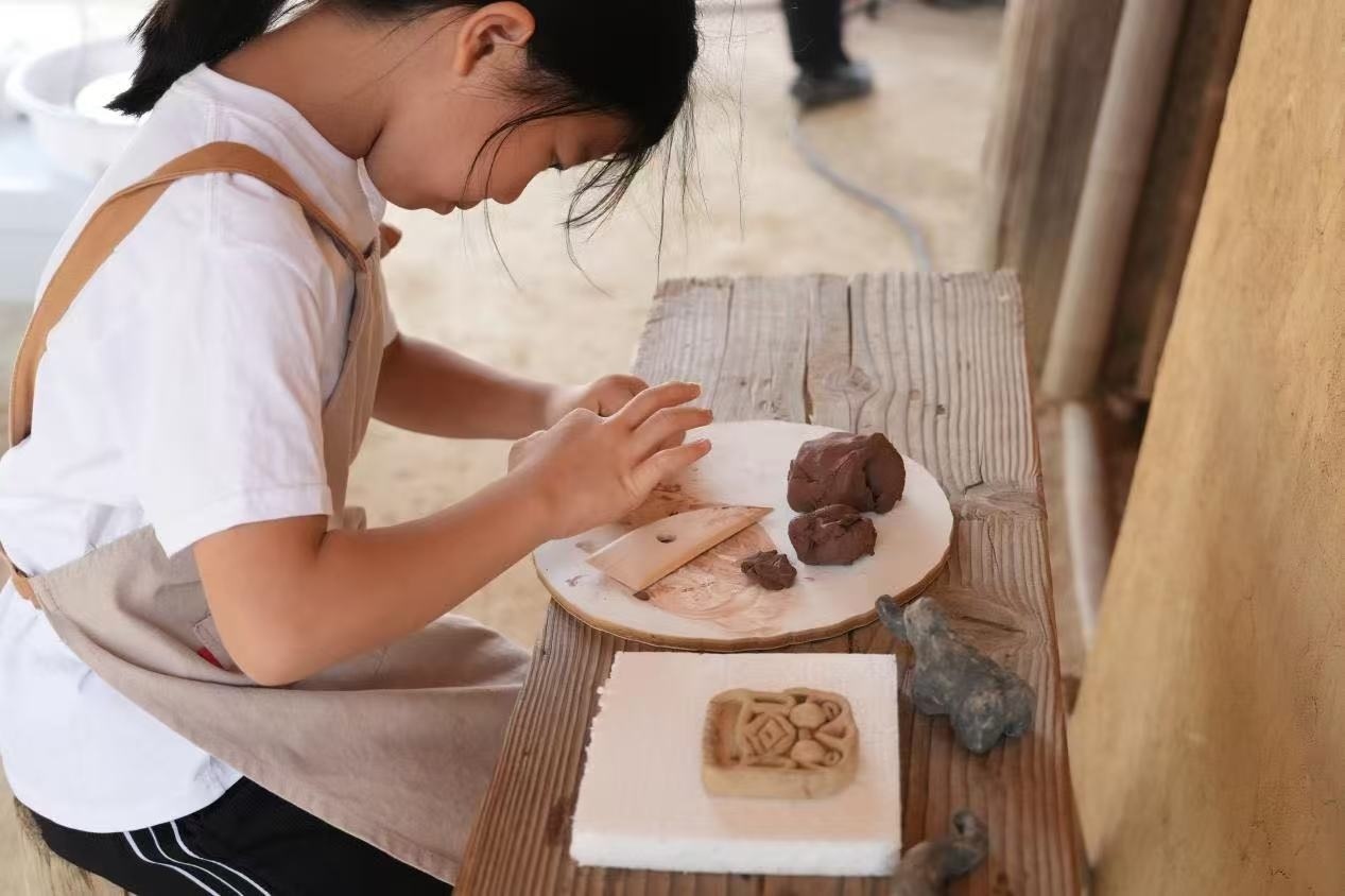 游客制作良渚特色陶藝品。良渚博物院供圖