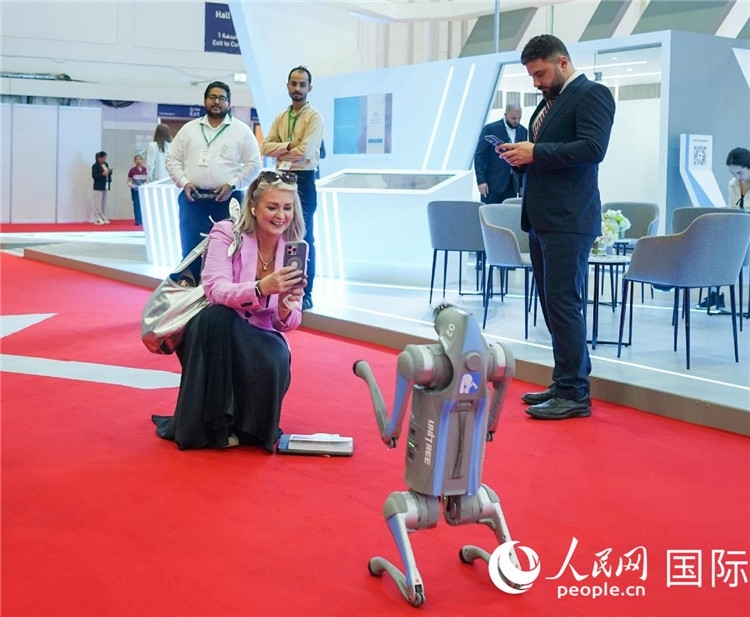 與會(huì)嘉賓被中企機(jī)器人吸引。人民網(wǎng) 塔里克·易卜拉欣攝