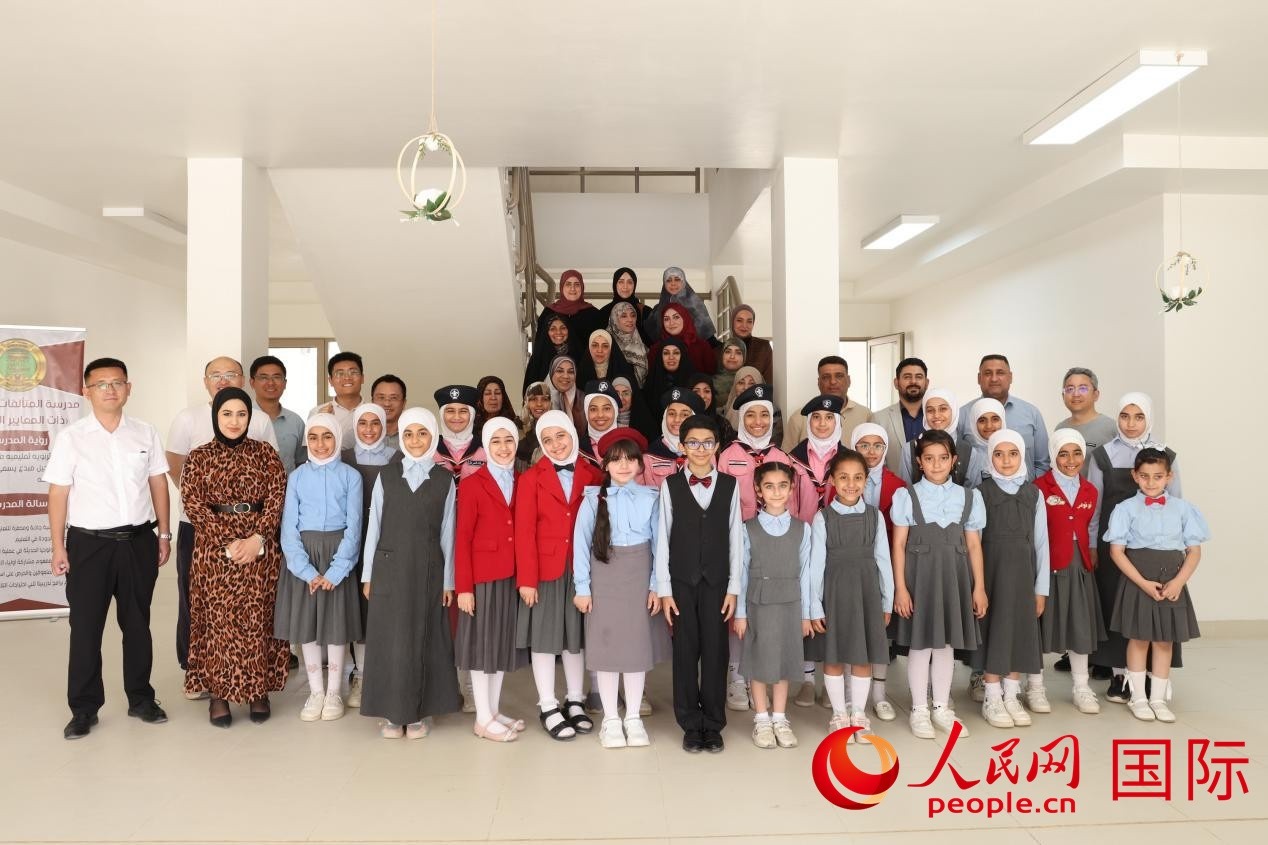 中國電建員工與阿爾穆塔?阿里卡特國際學(xué)校的師生及政府官員等合影。人民網(wǎng)記者 薛丹攝