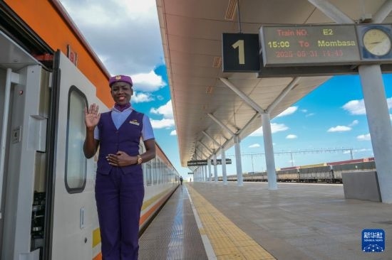 5月31日，在蒙內(nèi)鐵路內(nèi)羅畢站，一名乘務員在即將開往蒙巴薩的E2次列車旁等候乘客。新華社記者 楊光 攝