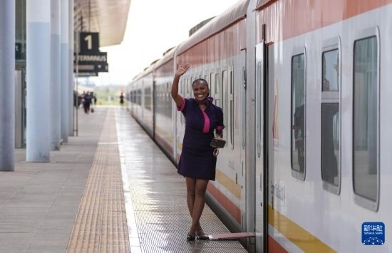 5月31日，在蒙內(nèi)鐵路內(nèi)羅畢站，一名乘務員在即將開往蒙巴薩的E2次列車旁等候乘客。新華社記者 李亞輝 攝