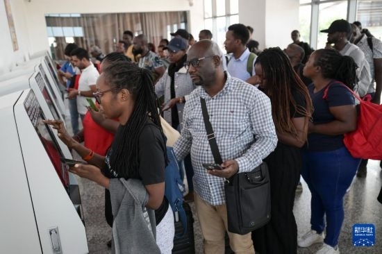 5月31日，在蒙內(nèi)鐵路內(nèi)羅畢站，乘客在自助取票機前排隊取票。新華社記者 楊光 攝