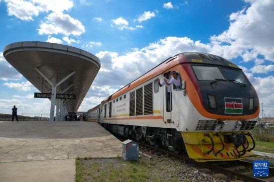 5月31日，在蒙內(nèi)鐵路內(nèi)羅畢站，機車駕駛員蔣立平（右）和博爾在即將開往蒙巴薩的E2次列車上揮手致意。新華社記者 楊光 攝