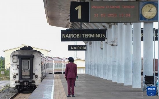 5月31日，在蒙內(nèi)鐵路內(nèi)羅畢站，工作人員目送開往蒙巴薩的E2次列車駛離站臺。新華社記者 李亞輝 攝